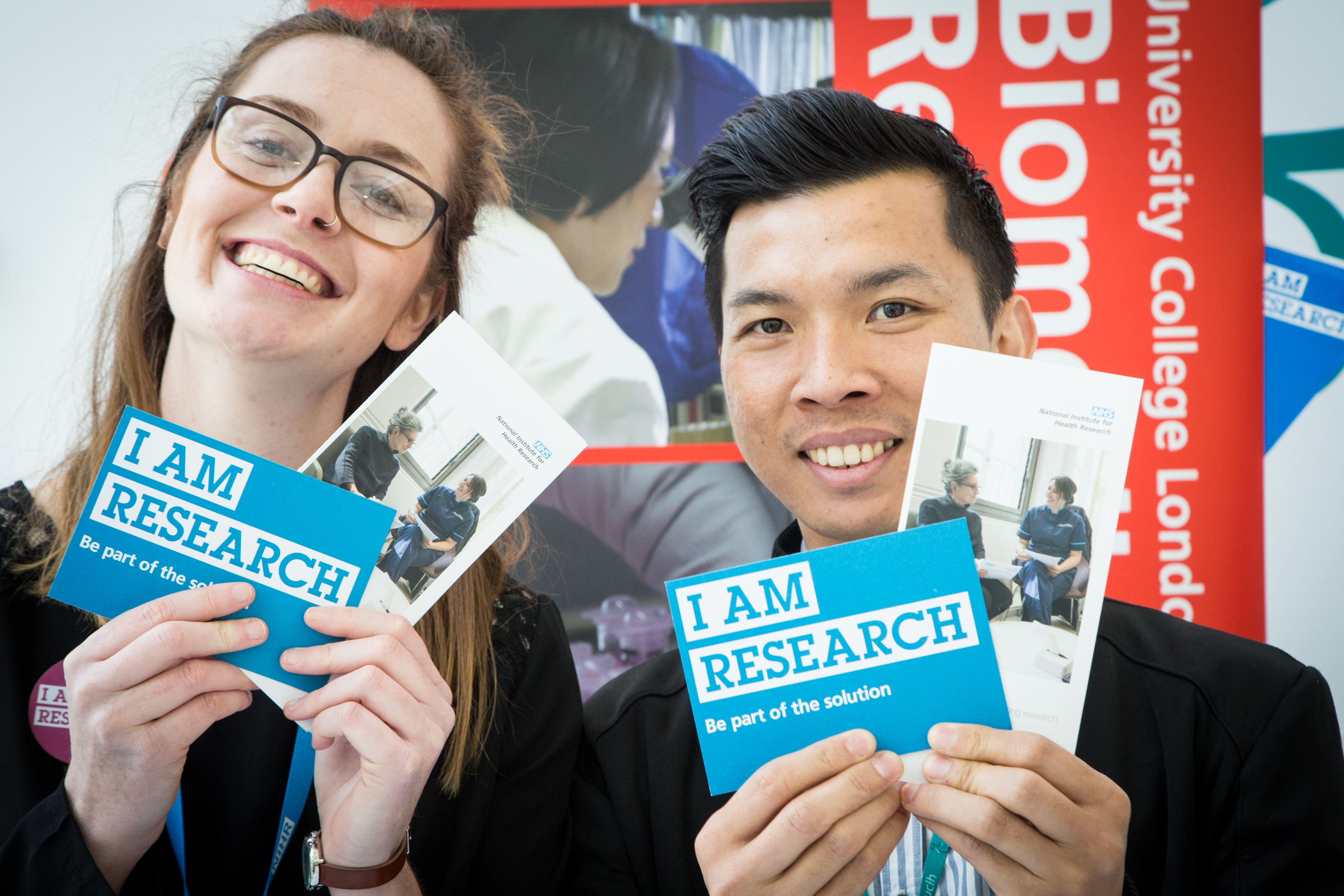Man and woman stood together holding research leaflets