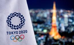 Tokyo at night with Tokyo Olympics 2020 flag in foreground