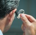Man putting in hearing aid
